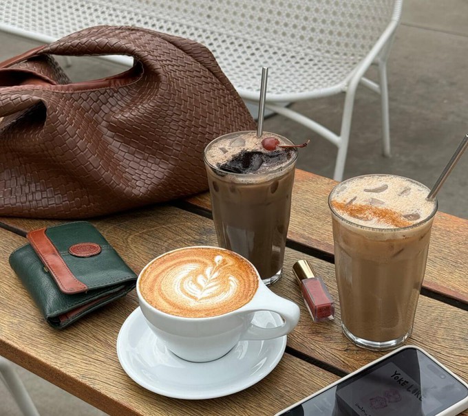 Handbag next to a coffee