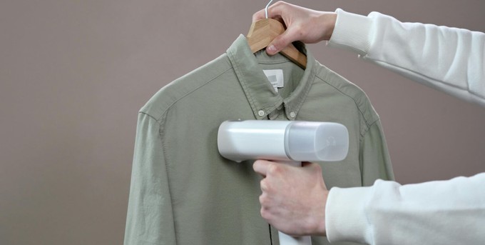 Someone steaming clothes as a green alternative to dry cleaning